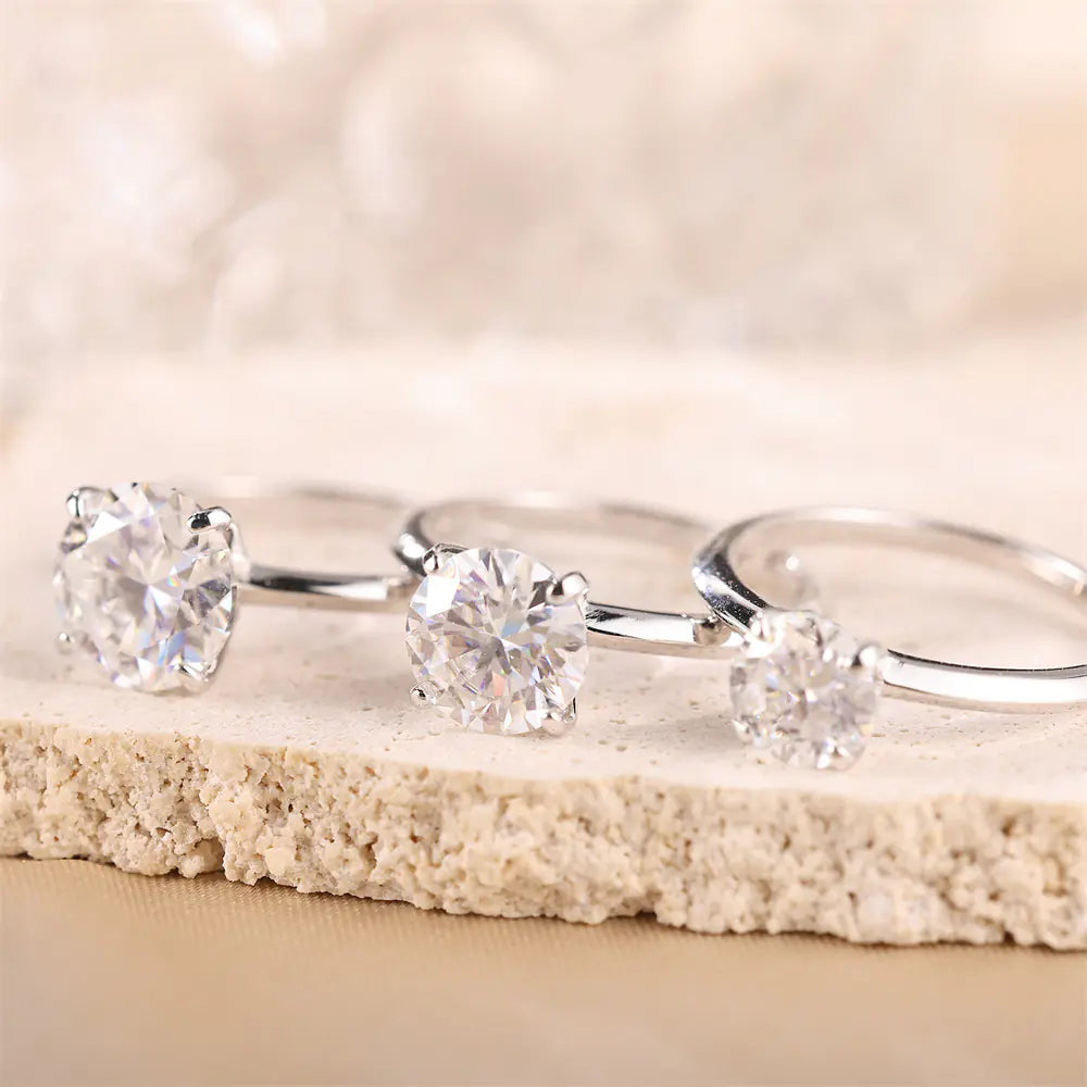 Moissanite solitaire rings in three sizes showing the scale comparison