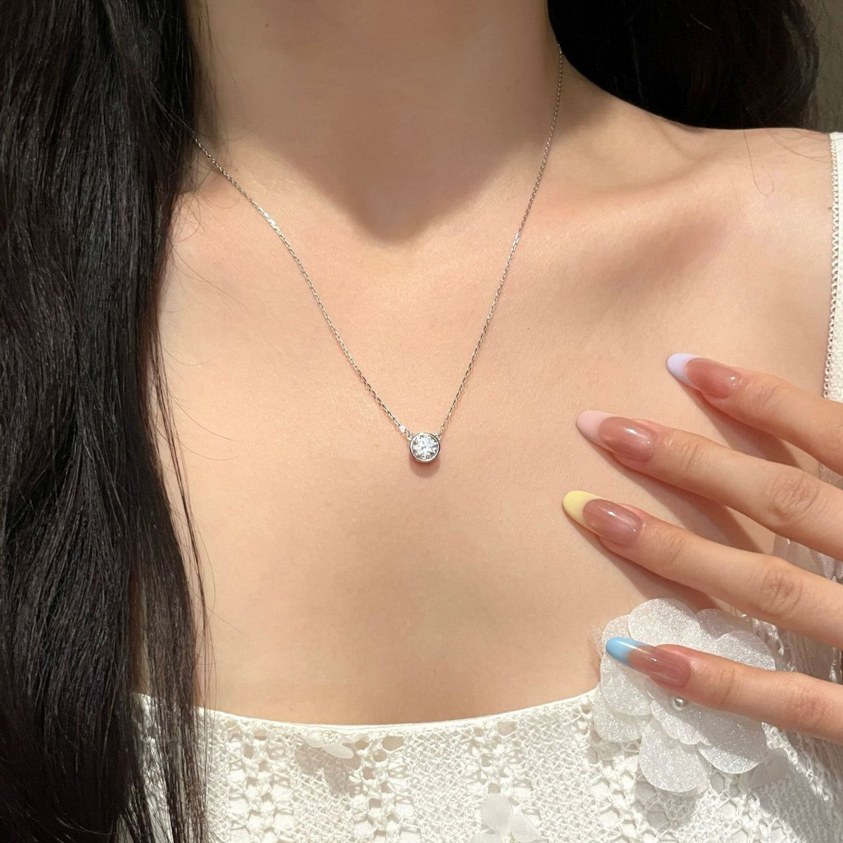 Bezel-set moissanite pendant necklace worn around the neck