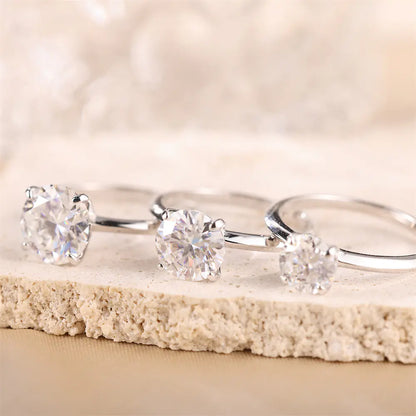 Moissanite solitaire rings in three sizes showing the scale comparison