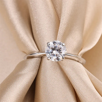 3 carat round moissanite solitaire ring resting on silk fabric