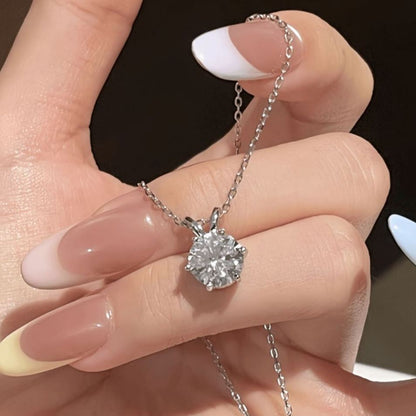 Six-prong moissanite solitaire pendant necklace held in hand