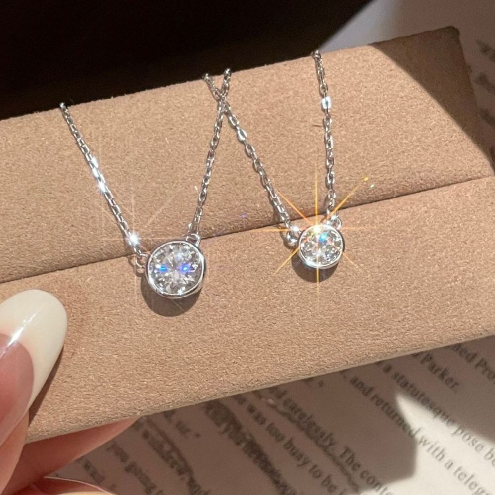 Bezel-set moissanite pendant necklace resting on a jewelry box