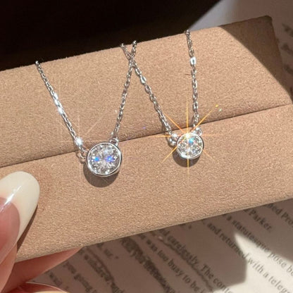 Bezel-set moissanite pendant necklace resting on a jewelry box